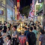 Crowds of visitors among street food stalls on a Myeongdong shopping street in Seoul at night