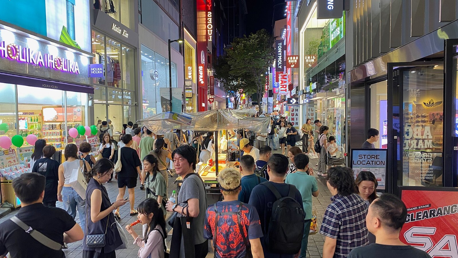 Crowds of visitors among street food stalls on a Myeongdong shopping street in Seoul at night
